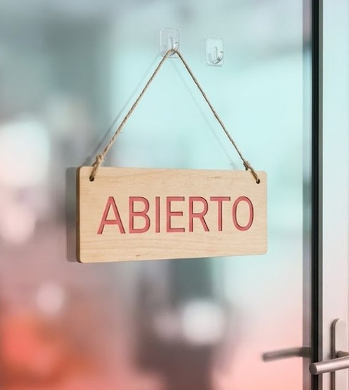 Letrero de madera que dice ABIERTO colgado en la puerta de un negocio